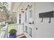 Close up of a white front door and entrance with a black mailbox, hooks, and an outdoor light at 1921 Clark Ave # 105, Raleigh, NC 27605