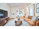 Comfortable living room featuring a modern leather couch and a view of the front yard at 1921 Clark Ave # 105, Raleigh, NC 27605