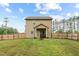 View of a two story home's backyard with a wooden fence, green grass, and a small porch at 20 W Park Ln, Sanford, NC 27332