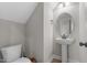 Stylish half bath with a pedestal sink, round mirror, and modern fixtures at 20 W Park Ln, Sanford, NC 27332