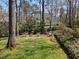 Large backyard featuring mature trees, a bird bath, and a seating area at 2005 Bridgeport Dr, Raleigh, NC 27615