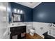Elegant half-bathroom boasts navy walls, wainscoting, and a dark vanity with modern fixtures at 2005 Bridgeport Dr, Raleigh, NC 27615
