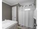 Neutral bathroom featuring a shower with window and white shower curtain at 2005 Bridgeport Dr, Raleigh, NC 27615