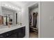 Bright bathroom featuring a dark vanity with modern fixtures and an open closet area at 2005 Bridgeport Dr, Raleigh, NC 27615