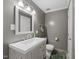 Clean bathroom with a white vanity, gray walls, updated fixtures, and tiled floors at 2005 Bridgeport Dr, Raleigh, NC 27615