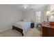 Well-lit bedroom with a floral bedspread, ceiling fan, neutral carpet, and natural light at 2005 Bridgeport Dr, Raleigh, NC 27615