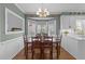 Charming dining room featuring a bay window, hardwood floors, and stylish wainscoting, ideal for entertaining at 2005 Bridgeport Dr, Raleigh, NC 27615