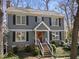 Classic two-story home with gray siding, black shutters, bright red door, and well-manicured landscaping at 2005 Bridgeport Dr, Raleigh, NC 27615