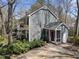 Charming two-story home with gray siding, red front door, mature trees and well-maintained landscaping at 2005 Bridgeport Dr, Raleigh, NC 27615
