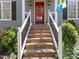 Elegant front entrance featuring brick steps, white railings, and a vibrant red door with glass panels at 2005 Bridgeport Dr, Raleigh, NC 27615