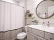 Well-lit bathroom features a large mirror, gray vanity, and a shower-tub combination at 2036 Big Falls Dr, Wendell, NC 27591