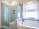 Stylish bathroom featuring a soaking tub, glass-enclosed shower, and modern fixtures at 2036 Big Falls Dr, Wendell, NC 27591