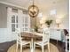 Charming dining room with a round wooden table, white chairs, and a stylish globe chandelier at 2036 Big Falls Dr, Wendell, NC 27591