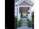 Inviting front porch with stone steps, white columns, a hanging swing, and decorative plants at 2036 Big Falls Dr, Wendell, NC 27591