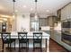 Stylish kitchen featuring gray cabinets, stainless appliances, an island with bar stools, and pendant lights at 2036 Big Falls Dr, Wendell, NC 27591