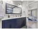 Modern bathroom with dual sinks, white countertops, dark vanity, and a glimpse of the bedroom at 209 Ashmore Ln, Rocky Mount, NC 27804