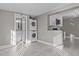 Open area with tile flooring, stackable washer/dryer, bathroom, and kitchenette with microwave and cabinets at 211 W Sycamore, Zebulon, NC 27597