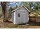 Exterior view of a storage shed with siding, a door, small window, and landscaping at 211 W Sycamore, Zebulon, NC 27597