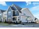 New townhome showcasing blue and gray siding, white trim, stone accents, and landscaped yard at 2469 Englemann Dr # 366, New Hill, NC 27562