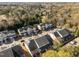 An aerial view showcases a neighborhood with well-maintained townhomes surrounded by lush trees and green spaces at 2523 Spring Oaks Way, Raleigh, NC 27614