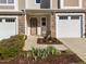 Inviting front porch with stone details, a white rocking chair, and a lovely garden bed at 2523 Spring Oaks Way, Raleigh, NC 27614