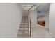 Carpeted staircase with white and wood railing leading to the upper level and a glimpse of the kitchen at 2523 Spring Oaks Way, Raleigh, NC 27614