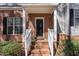 Home entrance features a brick facade, white railings, and a black front door for welcoming curb appeal at 2608 Broad Oaks Pl, Raleigh, NC 27603