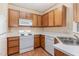 Functional kitchen layout with wooden cabinets, white appliances, and neutral countertops at 2608 Broad Oaks Pl, Raleigh, NC 27603