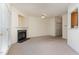 Bright living room features a fireplace, neutral carpet, and ample natural light from large window at 2608 Broad Oaks Pl, Raleigh, NC 27603