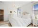 Light and airy bedroom with chandelier lighting, neutral decor, and natural light from the window at 2613 Forest Lake Ct, Wake Forest, NC 27587