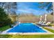 Beautiful in-ground pool, mature trees, and lounge chairs for a relaxing backyard retreat at 2613 Forest Lake Ct, Wake Forest, NC 27587