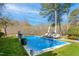 Relaxing backyard pool features lounge chairs, umbrellas, and professional landscaping at 2613 Forest Lake Ct, Wake Forest, NC 27587