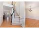 Elegant foyer featuring a staircase with black railings, hardwood floors, and a decorative chandelier at 2900 London Bell Dr, Raleigh, NC 27614