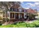 Charming brick home featuring a covered front porch with white columns and a well-maintained lawn at 2900 London Bell Dr, Raleigh, NC 27614