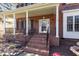 Inviting brick front porch with classic columns, seating area, and decorative front door at 2900 London Bell Dr, Raleigh, NC 27614