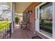 Covered front porch with comfortable seating, brick flooring, and a decorative glass front door at 2900 London Bell Dr, Raleigh, NC 27614