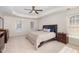 Main bedroom with carpet, large windows, tray ceiling and ceiling fan at 2900 London Bell Dr, Raleigh, NC 27614