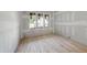 A bright bedroom featuring three windows and hardwood floors at 2957 Wexford Pond Way, Wake Forest, NC 27587