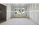 Bedroom featuring unfinished drywall, three windows overlooking the lush outdoors, and an open doorway at 2957 Wexford Pond Way, Wake Forest, NC 27587
