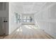 Sunlit living room featuring large windows, hardwood floors, and drywall in progress at 2957 Wexford Pond Way, Wake Forest, NC 27587