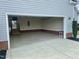 Open garage showcasing brick accents, storage hooks, and an easy transition to the interior stairs at 30 Wheat Dr, Angier, NC 27501