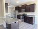 Modern kitchen with stainless steel appliances, granite countertops, and dark wood cabinets at 30 Wheat Dr, Angier, NC 27501