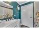 Teal bathroom with a modern vanity and decorative mirror and shower at 300 Lakeside Dr, Garner, NC 27529