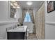 Bright bathroom features a single sink vanity, decorative mirror, large window, and a shower/tub combo with curtain at 300 Lakeside Dr, Garner, NC 27529