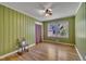 This bedroom features light green walls, hardwood floors, a ceiling fan, and a large window at 300 Lakeside Dr, Garner, NC 27529