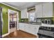 This updated kitchen boasts white cabinets, green backsplash, stainless appliances, and a window with wine glass storage above sink at 300 Lakeside Dr, Garner, NC 27529