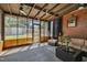 Enclosed porch with brick and wood beams, comfortable furniture and a ceiling fan at 300 Lakeside Dr, Garner, NC 27529
