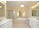 Luxurious main bathroom featuring dual vanities, a soaking tub, and separate shower at 335 Bridgegate Dr, Cary, NC 27519