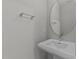Clean and simple half-bathroom with a pedestal sink and rounded mirror at 3409 Lily Orchard Way, Apex, NC 27539