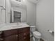 Bathroom featuring a vanity with a single sink, toilet, and mirror at 3409 Lily Orchard Way, Apex, NC 27539